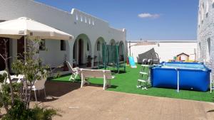 a patio with a playground with a table and an umbrella at Hotel Portugal in Lepe