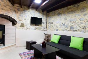 ein Wohnzimmer mit einem Sofa und einem TV in der Unterkunft Nivritos Traditional Homes in Nívritos