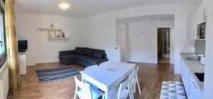 sala de estar con mesa blanca y sofá en Casa Gabbiano, en Nago-Torbole