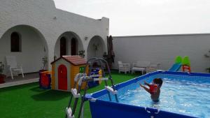 un niño jugando en una piscina en un patio trasero en Hotel Portugal en Lepe