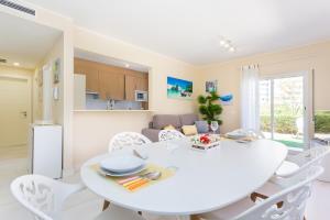 - une salle à manger blanche avec une table et des chaises blanches dans l'établissement Tropical Beach Apartment Litoralmar, à Portimão