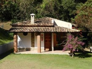 a small house with a roof on a yard at Pousada Cheiro de Mato in Monte Alegre do Sul