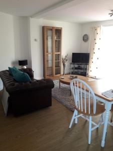 uma sala de estar com um sofá e uma mesa em The Cottage em Redruth