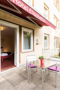 une table et des chaises devant un bâtiment dans l'établissement Hotel Elisabetha Garni, à Hanovre