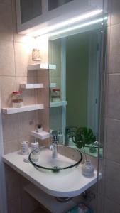 W łazience znajduje się umywalka i lustro. w obiekcie Olive garden guest house w mieście Kyparissia