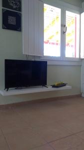 telewizor z płaskim ekranem siedzący na ławce w pokoju w obiekcie Olive garden guest house w mieście Kyparissia
