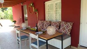 a table and chairs in a room with red walls at Olive garden guest house in Kyparissia
