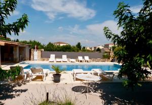 a swimming pool with chairs and a table next to it at Appartement Salvaterra in Sauveterre