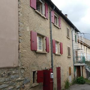 an old stone building with red shuttered windows at Maison à Font-Romeu - Odeillo in Odeillo-Via