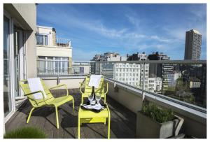 a balcony with two yellow chairs and a view of a city at Hotel Ter Streep in Ostend