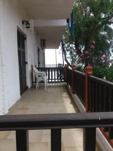 a balcony of a house with a white chair at House Kosmas on the beach in Sarti