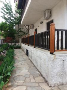 a stone walkway next to a house with a balcony at House Kosmas on the beach in Sarti