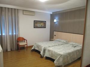 A bed or beds in a room at Hotel Corona de Castilla