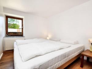 uma cama branca num quarto branco com uma janela em Modern Holiday Home in Meyerode with Terrace em Meyerode