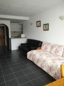 ein Wohnzimmer mit einem Sofa und einer Küche in der Unterkunft Maresol in Costa da Caparica