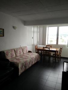 ein Wohnzimmer mit einem Sofa und einem Tisch in der Unterkunft Maresol in Costa da Caparica