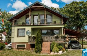 a house with a balcony and a car parked in front at U Gacka in Władysławowo