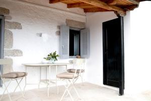 a white room with a table and chairs at Unique Home with Serene Panoramic Views in Kalívia