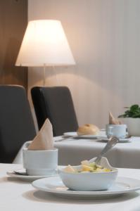 
a white table topped with plates and bowls of food at Hotel Ter Streep in Ostend
