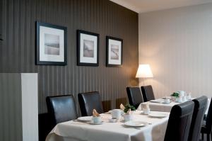 a dining room with two tables and black chairs at Hotel Ter Streep in Ostend