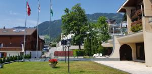 un edificio con una bandera en el césped junto a un edificio en Route du Village 5 Residence Panorama, en Villars-sur-Ollon