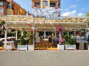 a restaurant with flowers in front of a building at Victorio Lux Apartments in Sveti Vlas