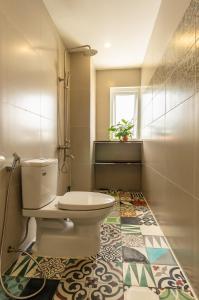 baño con aseo y suelo de baldosa. en D Central Hoi An Homestay, en Hoi An