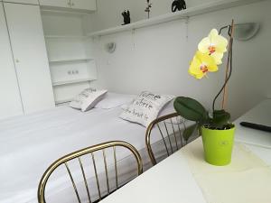a white bedroom with a bed and a plant on a desk at MB apartment Bled in Bled