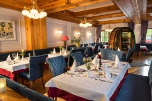 uma sala de jantar com mesas, cadeiras e lustres em Hotel Teichwirt em Fladnitz an der Teichalm