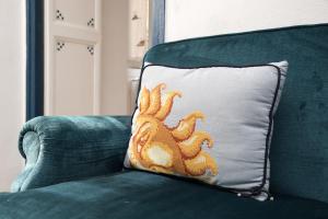 a pillow with an orange octopus on it sitting on a couch at Casa Mira Parasio in Imperia