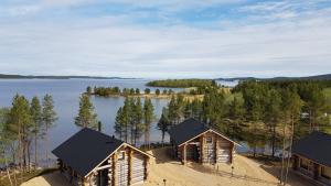 Wilderness Hotel Inari & Igloos في إيناري: اطلالة جوية على كوخ خشبي على بحيرة