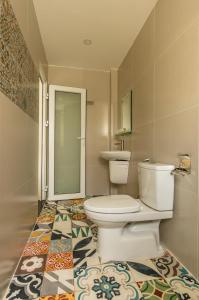 D Central Hoi An Homestay في هوي ان: حمام مع مرحاض ومغسلة على أرضية من البلاط