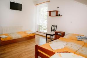 a bedroom with two beds and a desk and a tv at U Gacka in Władysławowo