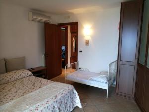 a bedroom with two beds and a crib at La Petite Maison - Panoramic Apartment di Terry De Martino in Vico Equense