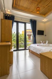a bedroom with a bed and a large window at D Central Hoi An Homestay in Hoi An