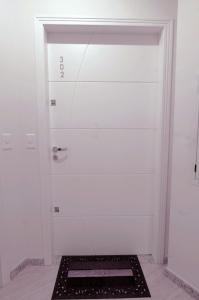 Una puerta blanca con una rejilla negra en una habitación en Villa das Ondas - Mariscal, en Bombinhas