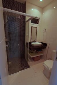 y baño con ducha, aseo y lavamanos. en Villa das Ondas - Mariscal, en Bombinhas