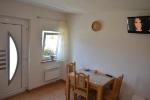 a dining room with a table and chairs and a window at Blue Lake Luxury Rooms in Grabovica