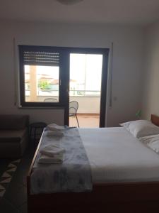 Un dormitorio con una cama grande y una ventana en Apartments Juric, en Baška Voda