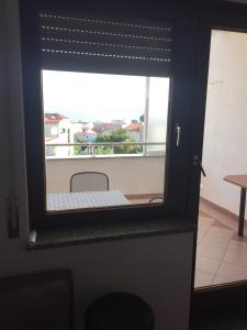 a window in a room with a view of a balcony at Apartments Juric in Baška Voda