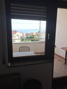 a door with a window with a view of a balcony at Apartments Juric in Baška Voda