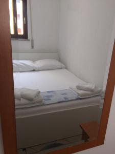a white bed with two pillows on it at Apartments Juric in Baška Voda