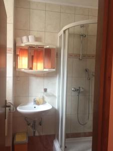 La salle de bains est pourvue d'un lavabo et d'une douche. dans l'établissement Apartments Juric, à Baška Voda