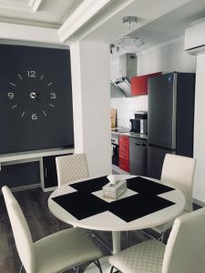 Apartment in Torrevieja Centre في توريفايجا: مطبخ مع طاولة وكراسي وساعة على الحائط