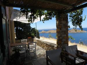 a patio with a table and chairs and a view of the ocean at Spitakia in Vourkari