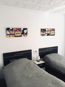 Apartment in Torrevieja Centre في توريفايجا: غرفة نوم بسريرين وملصقات على الحائط