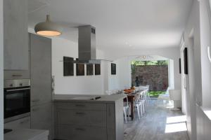 cocina blanca con mesa y comedor en Subtil insolite en Colmar