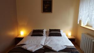 a bedroom with a bed with two lamps on it at Dom Gościnny Korab in Kołobrzeg