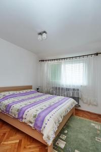 a bedroom with a bed and a green rug at Apartman Jovana Sokobanja in Soko Banja