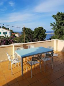 a blue table and chairs sitting on a balcony at Buganvilija C6 in Veli Lošinj